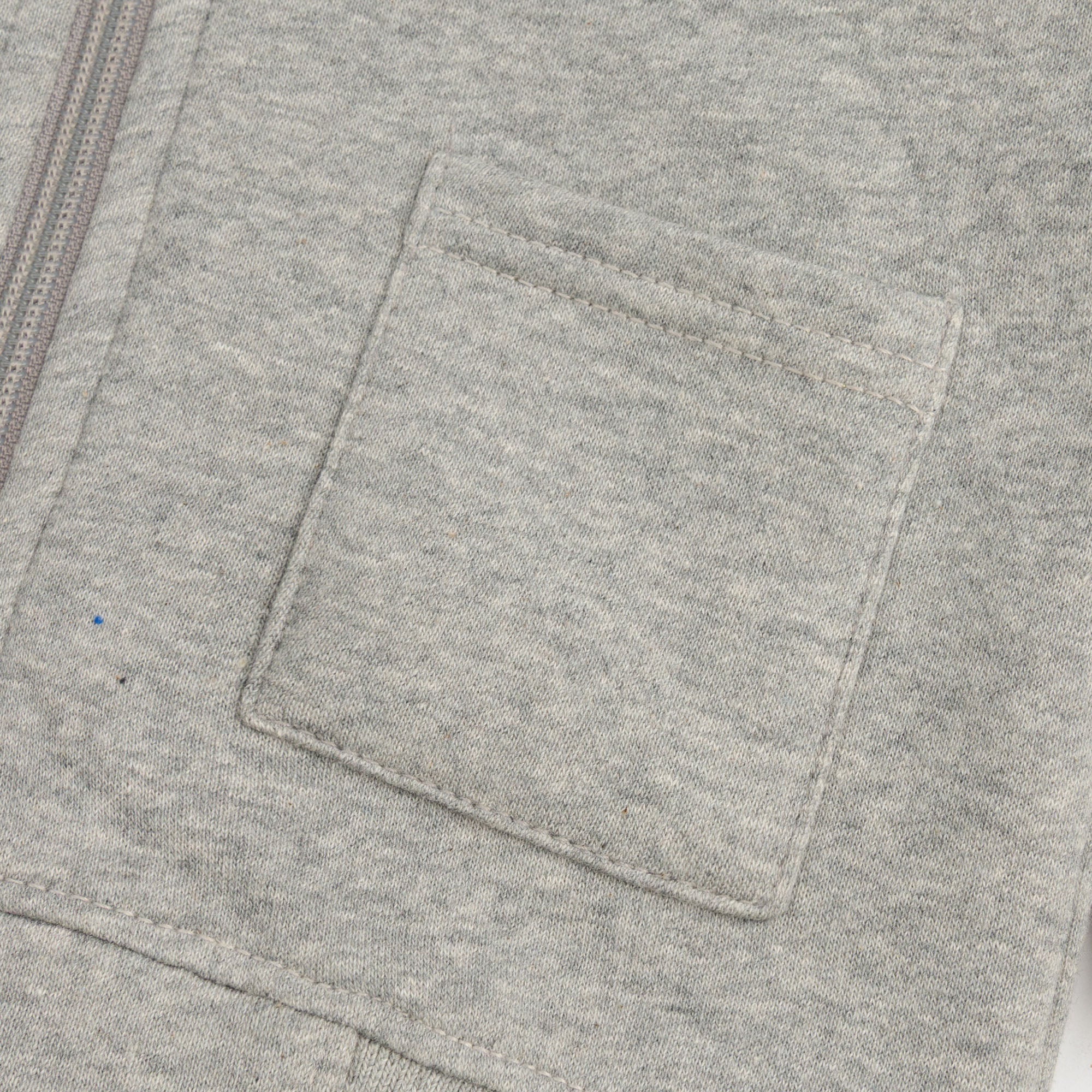 Close-up of the front patch pocket and zip detail on the heather grey boys’ fleece hoodie.