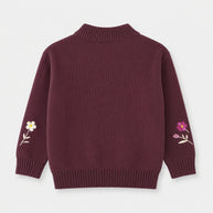 Back view of the girls deep-plum cotton sweater, showing a plain finish, floral embroidery on both sleeves and a ribbed mock neckline.