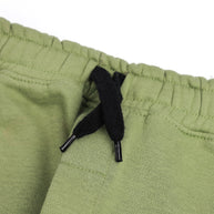 Close-up of the elasticated waistband and contrast black drawstring on the boys sage green fleece joggers.