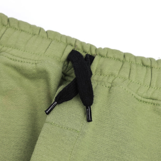Close-up of the elasticated waistband and contrast black drawstring on the boys sage green fleece joggers.