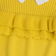 Close-up view of the layered yellow ruffle details, ribbed texture and white scalloped collar on the girls cotton sweater.
