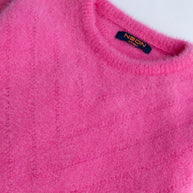 Close-up view of the ultra-soft and fluffy bright pink feather yarn texture on the girls crew neck sweater.