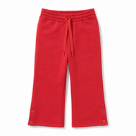 Front view of the girls red fleece trousers featuring a flared silhouette, drawstring waist and button-tab ankle details.
