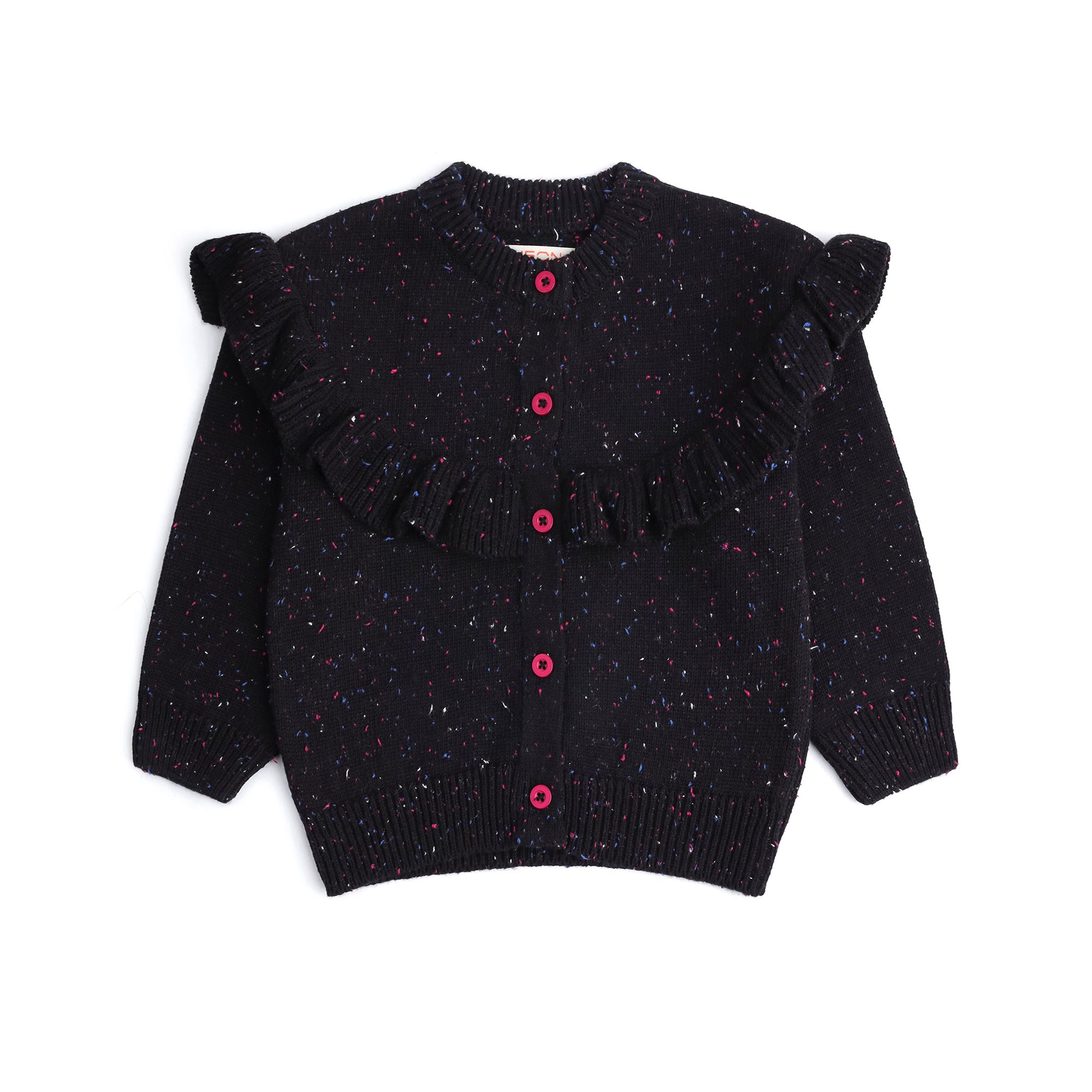 Front view of a black cotton cardigan for girls, featuring multicolor speckles, a statement ruffle across the shoulders and front, pink buttons and ribbed edges.