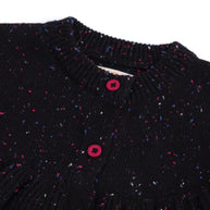 Close-up view of the girls black cotton cardigan, showing its ribbed neckline, pink buttons and fine pink, blue and white speckled knit detailing.