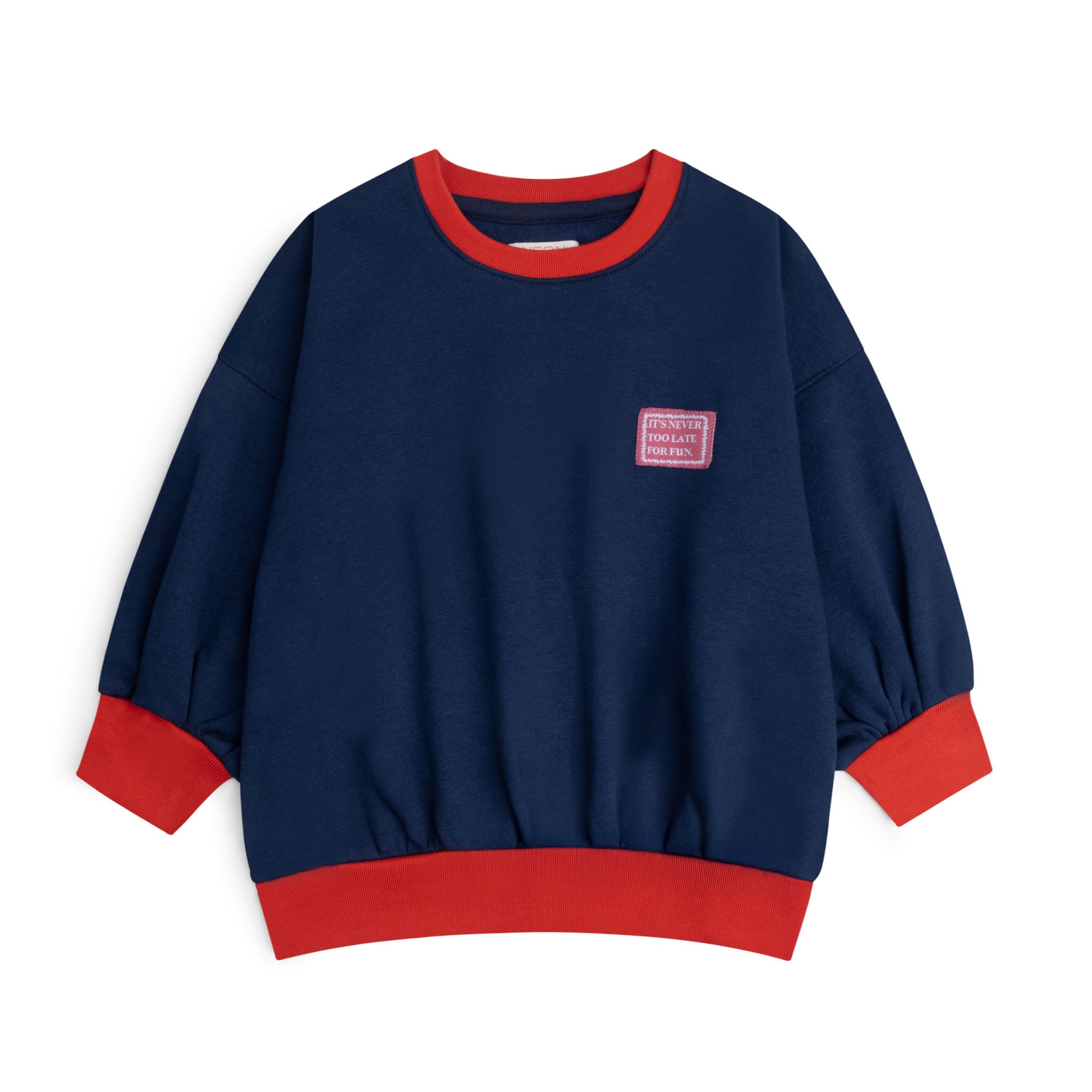 Navy blue fleece sweatshirt for boys featuring contrast red neckline, cuffs and hem, dropped shoulders and a chest slogan patch.