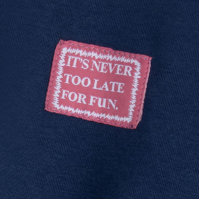 Close-up of the “It’s Never Too Late for Fun” slogan patch on the boys navy fleece sweatshirt.