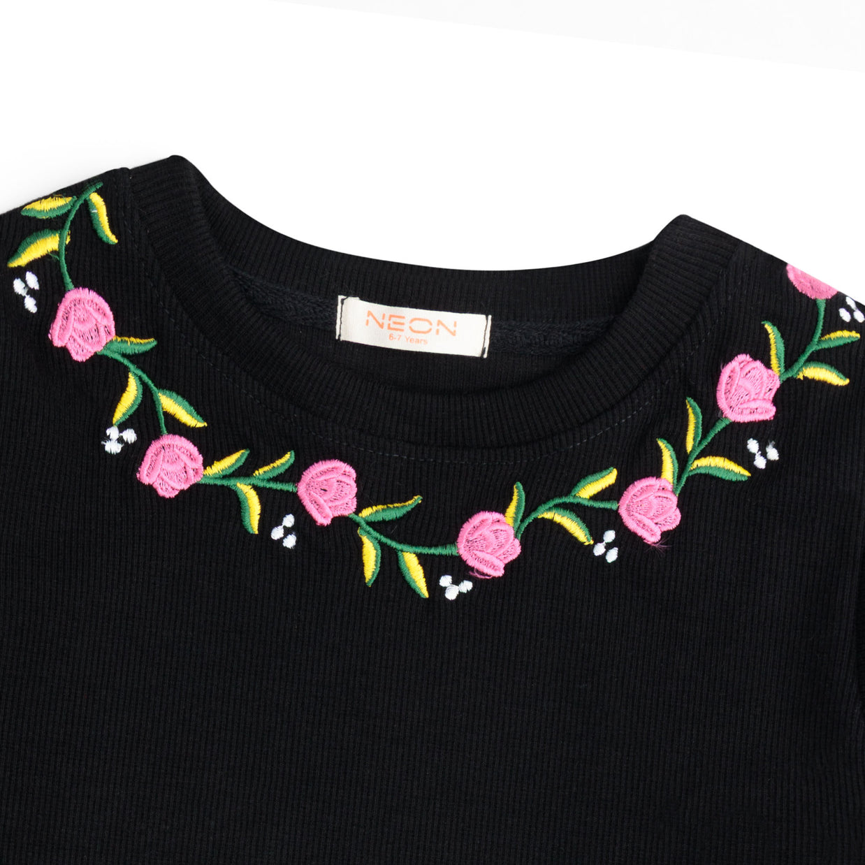 Close-up view of the pink, green, yellow and white floral embroidery around the neckline of the girls black rib sleeveless top.