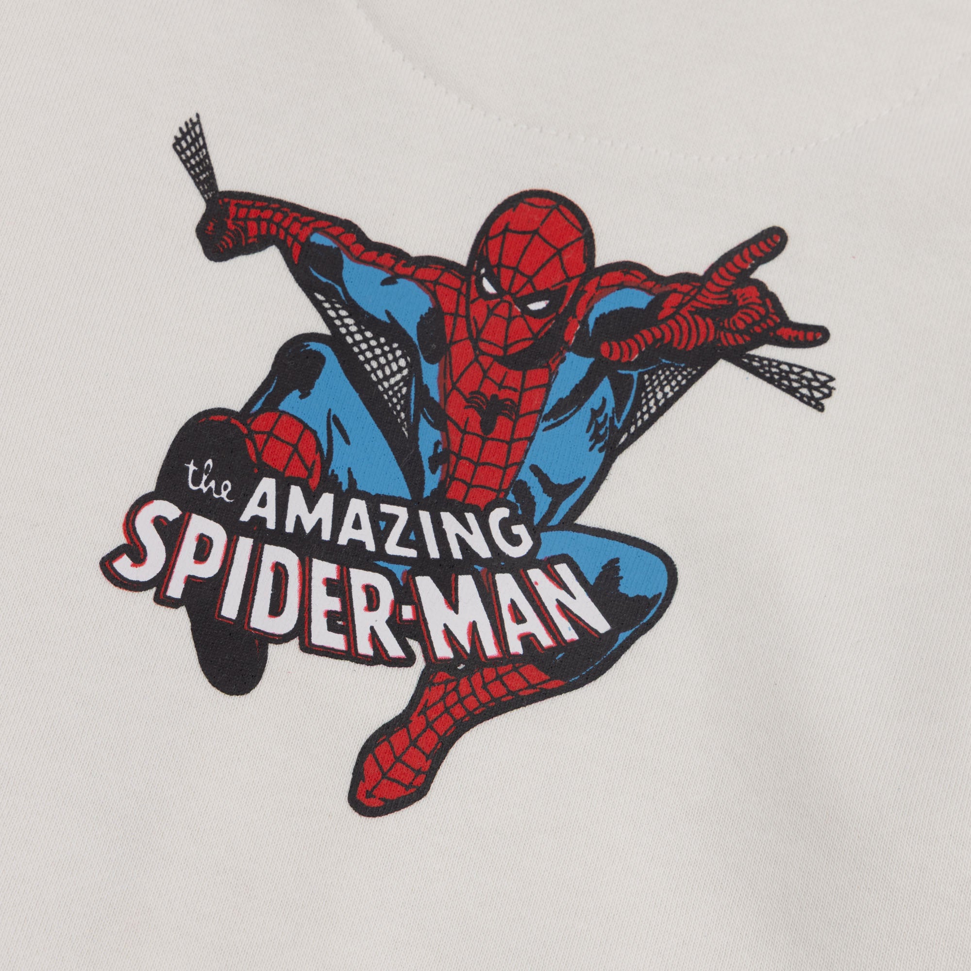 Close-up of the red, blue and black Amazing Spider-Man graphic printed on the boys off white fleece hoodie.