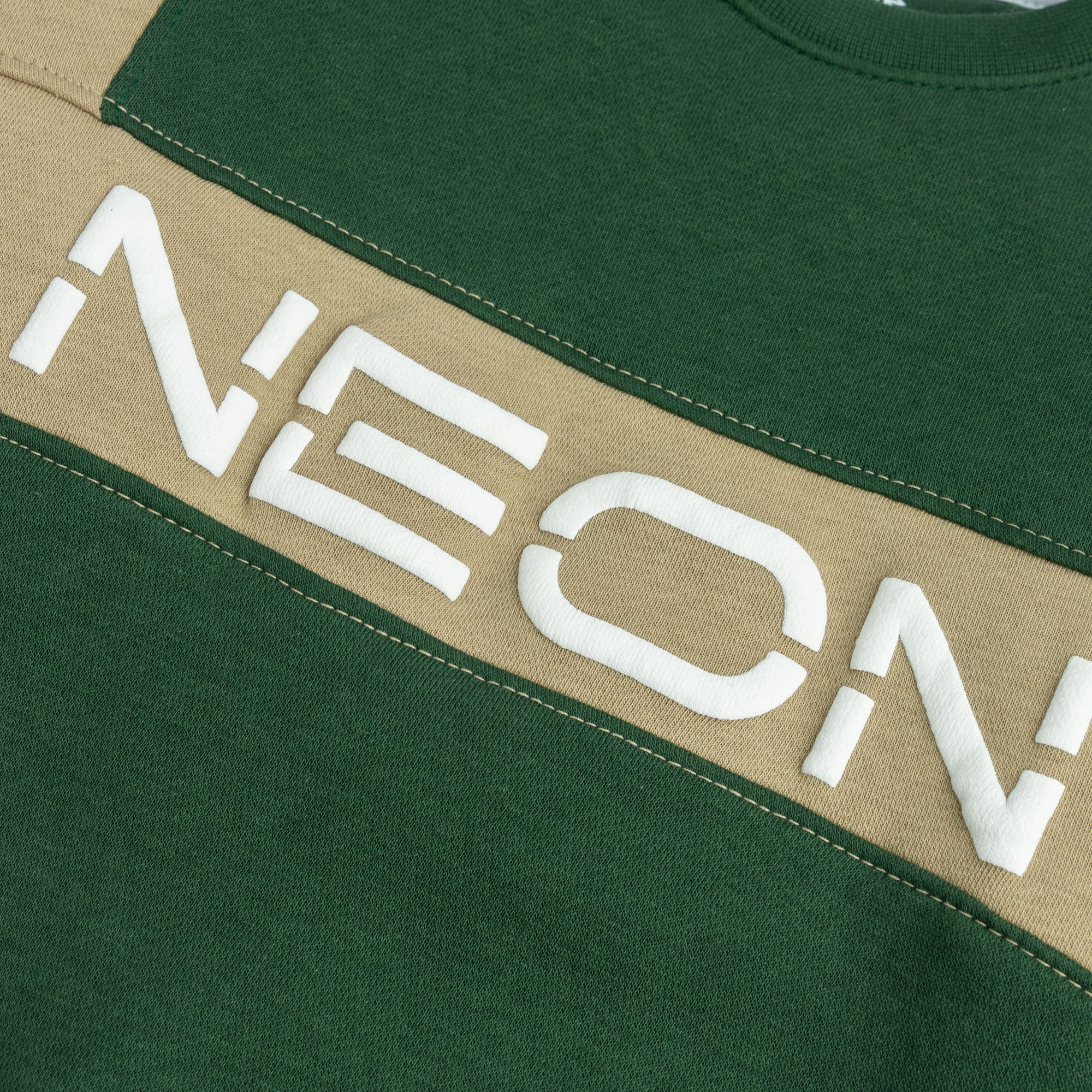 Raised NEON logo and khaki color block panel on forest green sweatshirt