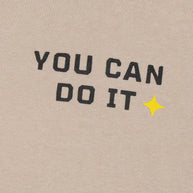 Close-up of the black You Can Do It text and yellow star graphic printed on the boys beige fleece sweatshirt.