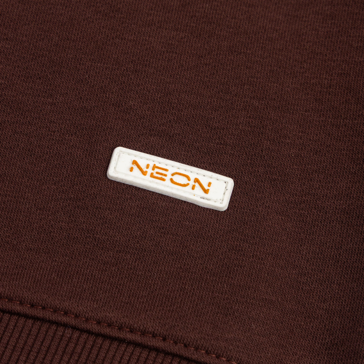 NEON logo badge and ribbed hem detail on espresso brown fleece sweatshirt