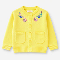 Front view of a lemon-yellow acrylic cardigan for girls, featuring colorful butterfly and floral embroidery, matching buttons and two patch pockets.