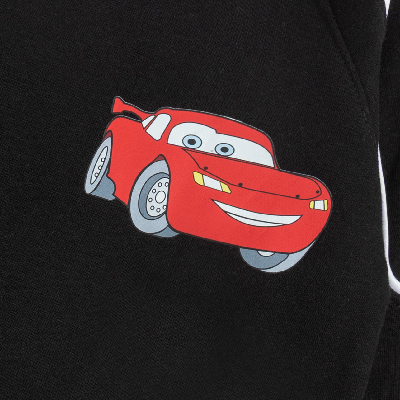 Close-up of the red racing car graphic and white piping detail on the black boys’ sweatshirt.