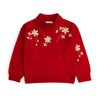 Girls red acrylic sweater featuring floral embroidery across the front and sleeve, a folded mock neck, long sleeves and ribbed edges.