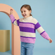 Smiling young girl wearing a multicolor striped mock-neck sweater featuring cream, purple and pink panels.